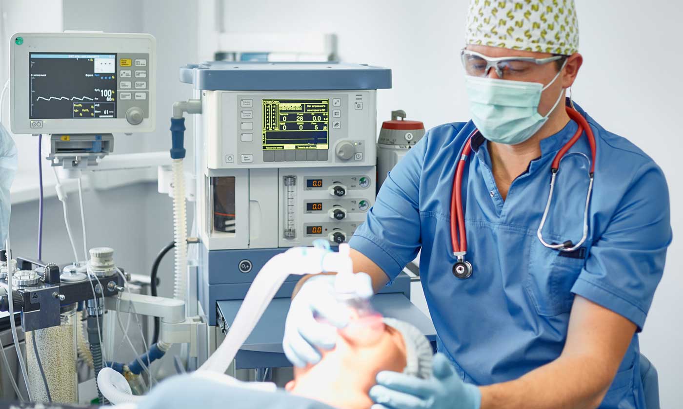 Anesthetist administering anesthesia to patient before surgery